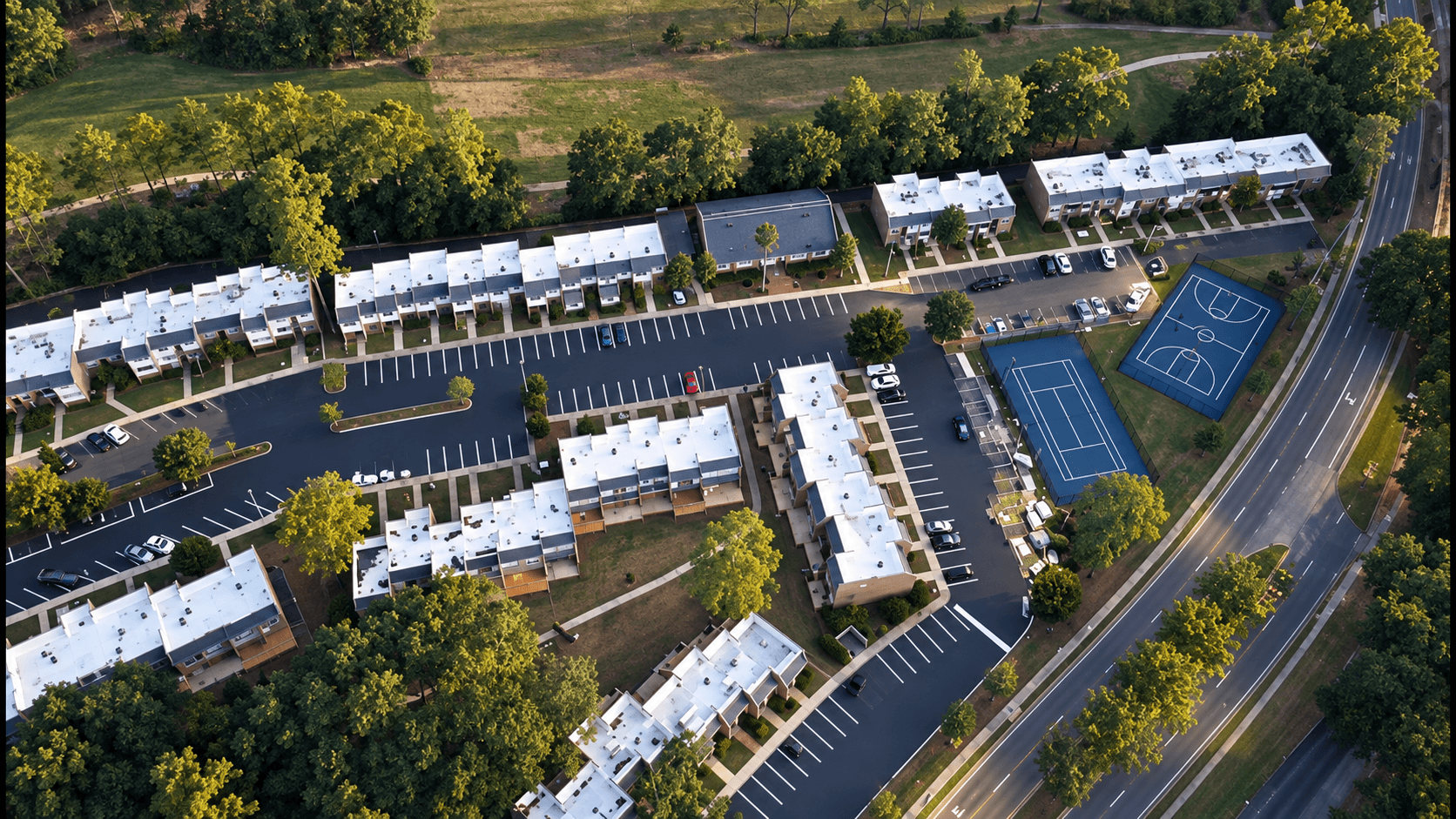 Aerial view of a multi-family residential complex in Tallahassee, FL with freshly paved parking lots and clean white stall striping