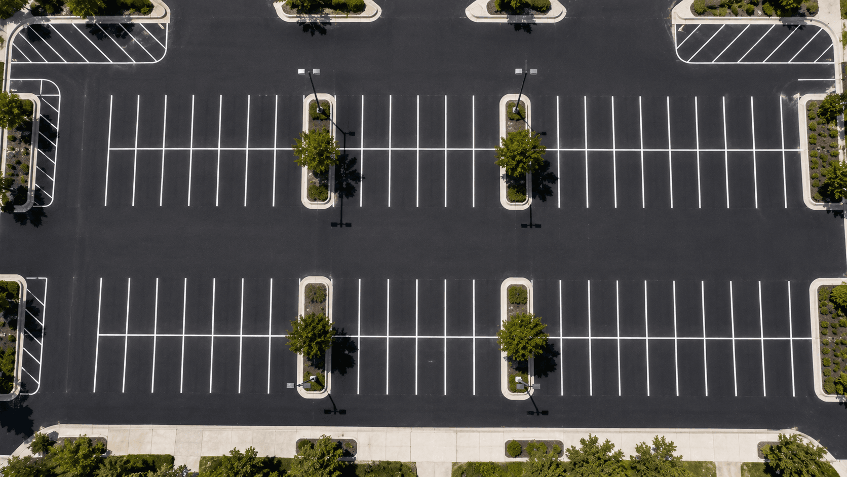 Overhead view of a commercial parking lot showing precise white stall line dimensions